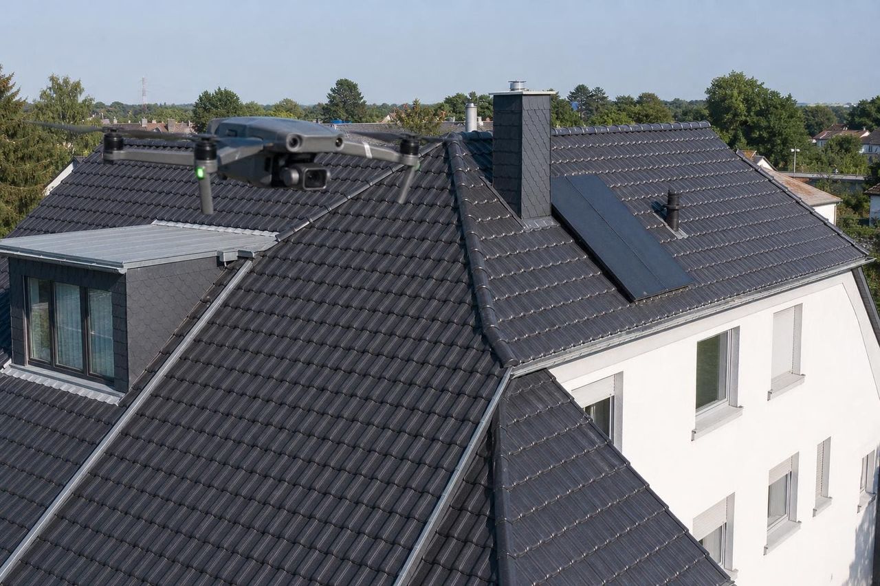 Drohne über einem Hausdach bei der Inspektion — sichere Alternative zum Gerüst